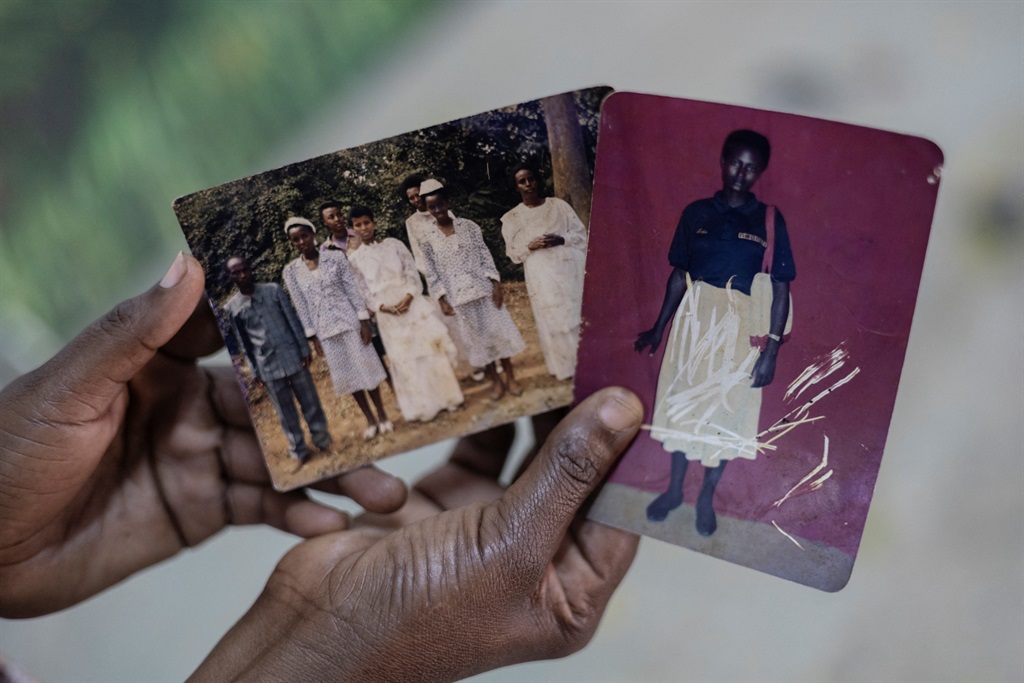 Rwandan Genocide survivor Nyirahabimana Aliette , 41, holds photographs of her family members that were killed in the 1994 Rwanda Genocide, for them to be drawn in Kigali on 2 April 2024. (Guillem Sartorio / AFP)