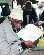Mayor Mxolisi Kaunda hands over a title deed to a grateful Gogo Mntwanase Zungu.