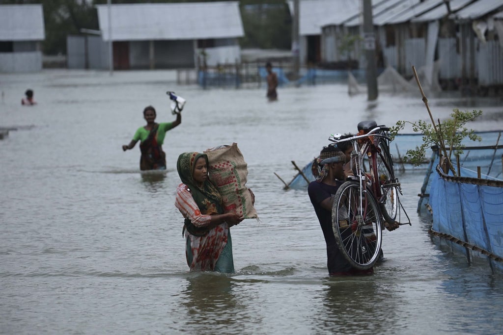  People make their ways to take shelter in cyclone center after their houses flooded by cyclone Yaas in Koyra Upozila in Bangladesh on May 26, 2021. (Photo by Zakir Hossain Chowdhury/Anadolu Agency via Getty Images)
