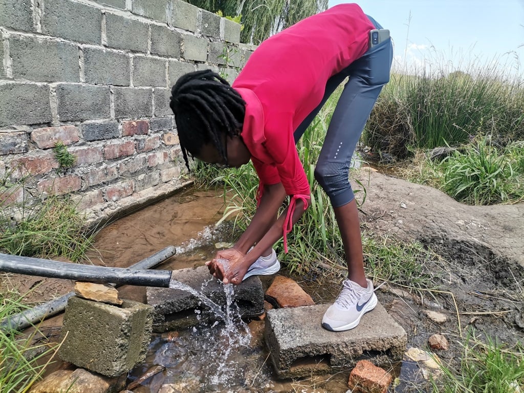 Nondumiso Mabuza consuming water from the ground.  Photo by Bulelwa Ginindza 