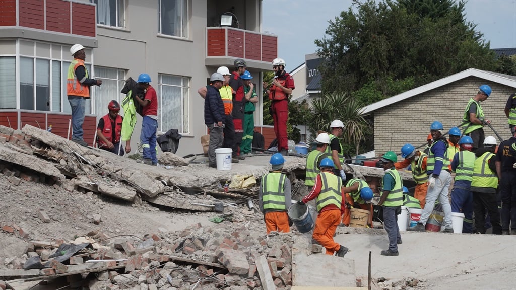 Rescue teams on site remove rubble and bricks as the search for victims continues. (Luke Daniel/News24)