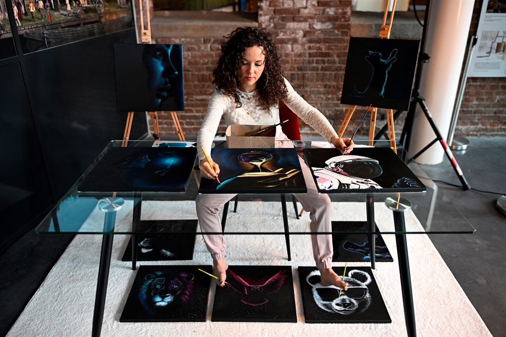 Dutch artist Rajacenna van Dam, paints ten paintings at once with both hands and feet, live in a museum in Vlaardingen, on 3 May 2024. (John Thys/AFP)