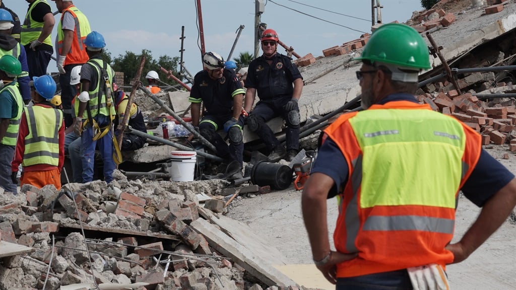 Rescue teams on site remove rubble and bricks as the search for victims continues. (Luke Daniel/News24)