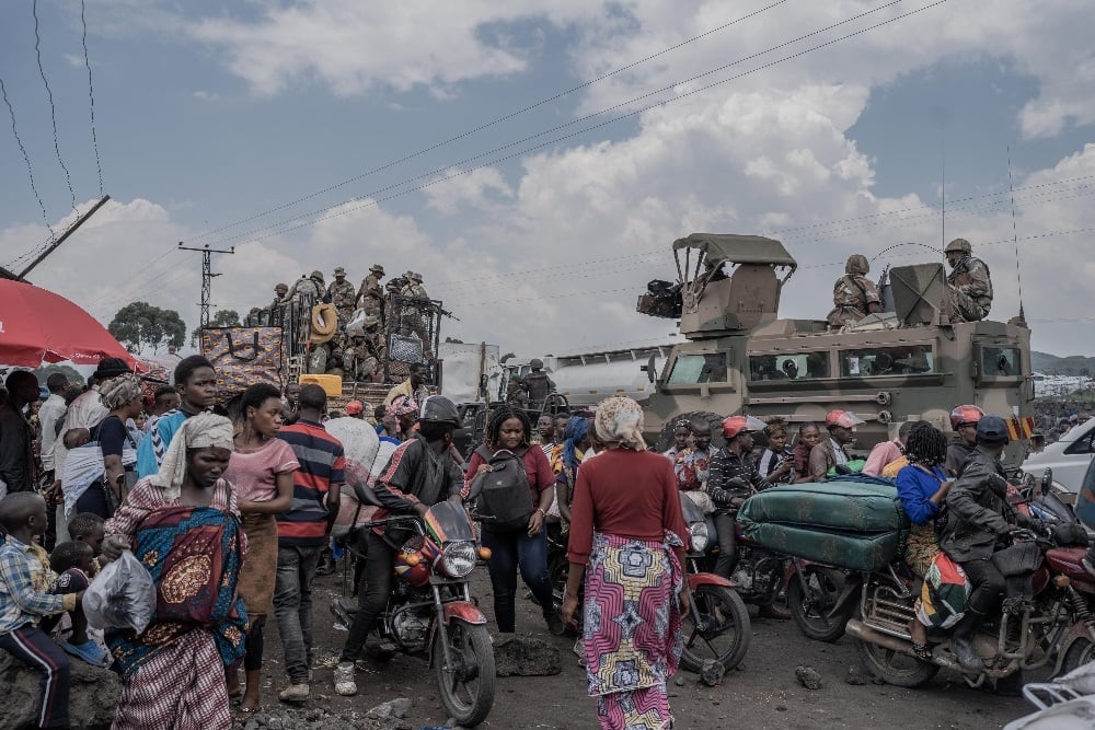 People gather around SANDF vehicles deployed for the SADC Mission in DRC as they flee the Masisi territory following clashes between M23 rebels and government forces on 7 February 2024. (Aubin Mukoni/AFP)