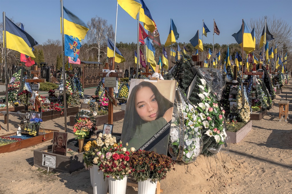 The portrait of 23 year-old Valentyna Makarenko, a Ukrainian machine gunner who was killed fighting Russian forces in the Kharkiv region in January, on her grave in the Alley of Heroes cemetery, in Kyiv, on 8 March 2024. (Roman PILIPEY / AFP)