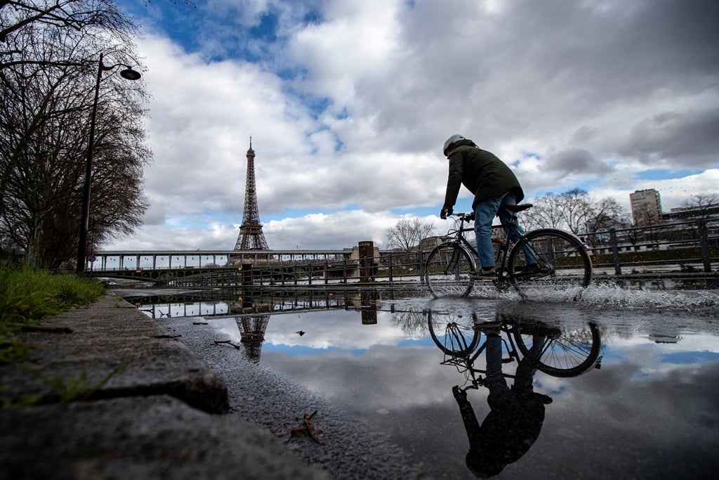 A cyclist rides along the flooded Seine river banks with the Eiffel Tower appearing in the background in Paris on 5 March, 2024. (Guillaume Baptiste / AFP)