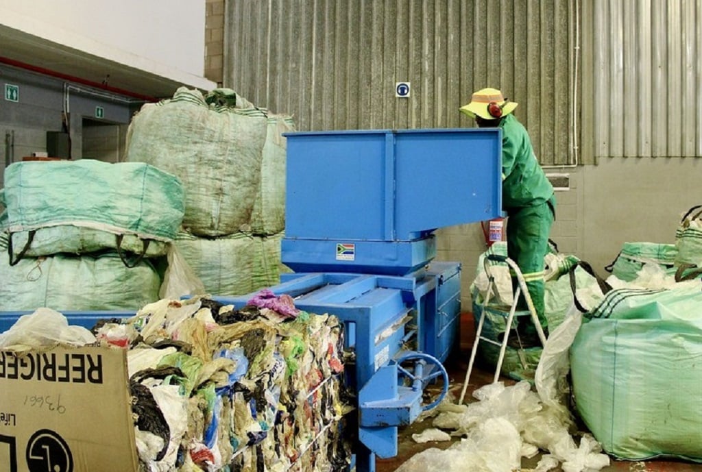 Recyclable items collected and sorted at the African Reclaimers Organisation’s sorting centre are compressed using a baler machine before being sold to buy-back centres. (Masego Mafata/GroundUp)