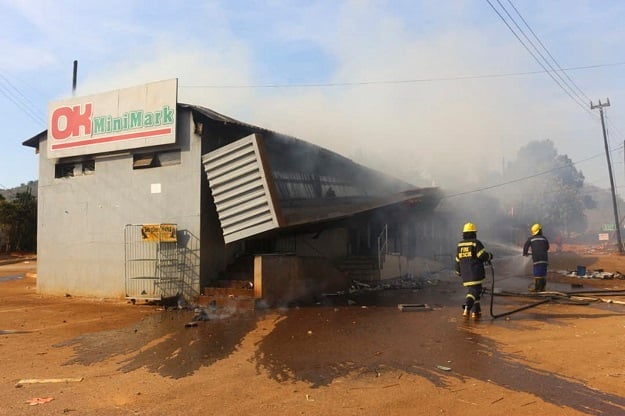 Firefighters extinguish a fire at a supermarket during eSwatini protests.
