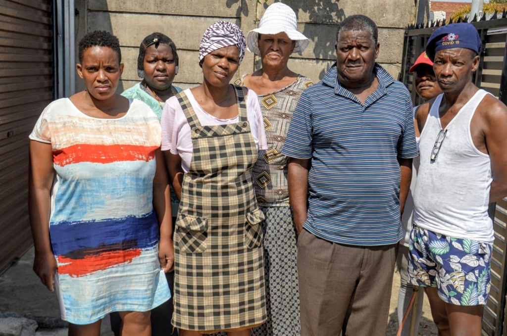 Penelope Rasego with a doek (55) and Josiah Sithole (68) (with a striped T-shirt), cousin to the late Reuben Solomon Mogale (62) with neighbours who claim Angie Nobela buried Solomon without their knowledge. Photo by Raymond Morare
