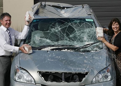 AMAZING JOURNEY: Ashley and Christine Vendt stand next to their pulverised Lexus, following their harrowing journey to escape the earthquake which devastated Christchurch, New Zealand.