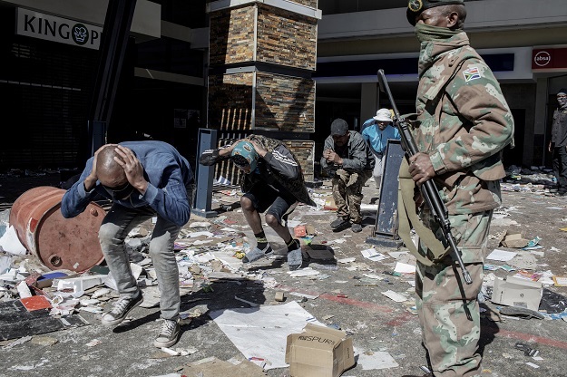 SANDF soldiers and police officers detain suspected looters at Jabulani Mall in Soweto.