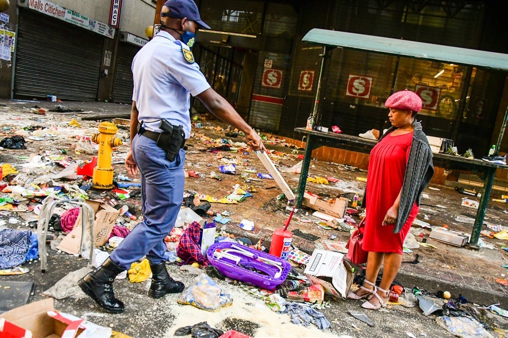 A police officer and civilian woman outside Shoprite in the Durban CBD on July 12, 2021 amid civil unrest and looting.