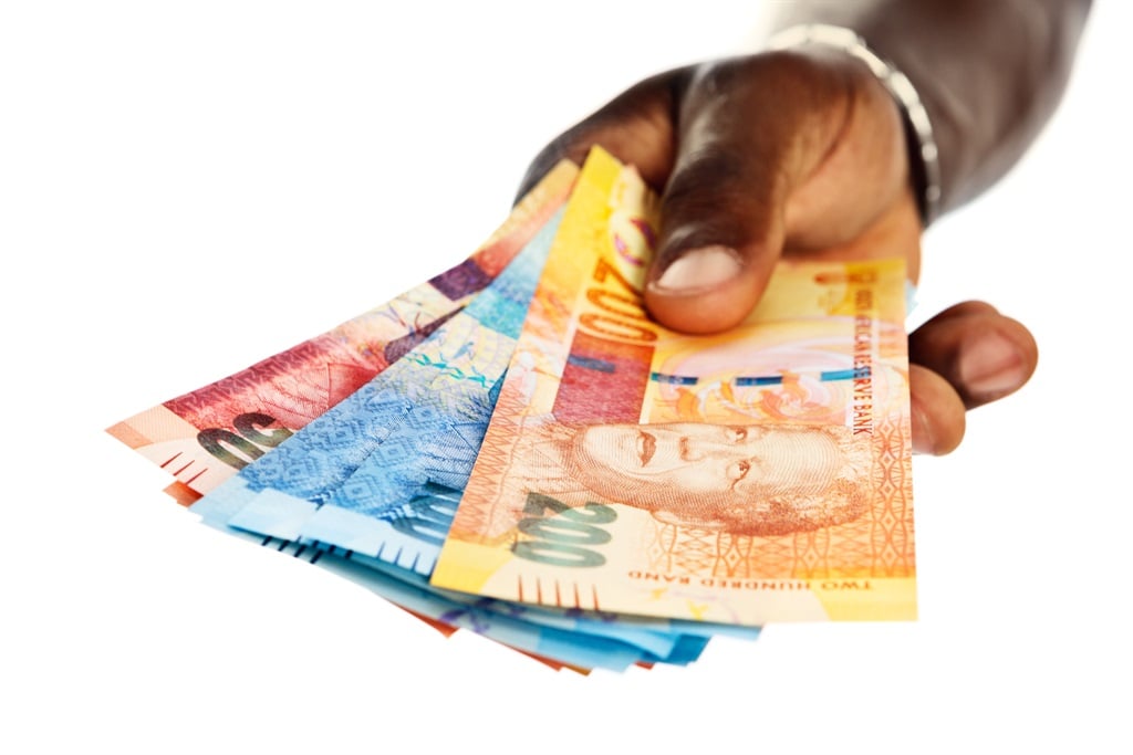A mans hands hold out a bundle of the new South African notes