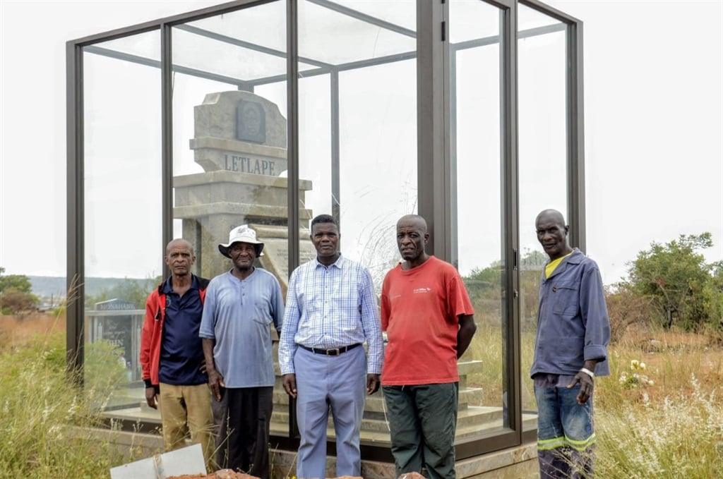 Family members Moses Masheqa (59), Molefe Matlwa (81), Philemon Kgopa (62), Andrew Moeletsi (58) and Solly Mokgethoa (59) standing in front of the vandalised tombstone. Photo by Raymond Morare 