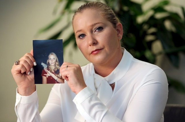 Virginia Giuffre holds a photo of herself taken a year after she started working for Jeffrey Epstein, who was later convicted of procuring an underage girl for prostitution. (PHOTO: Gallo Images/Getty Images) 