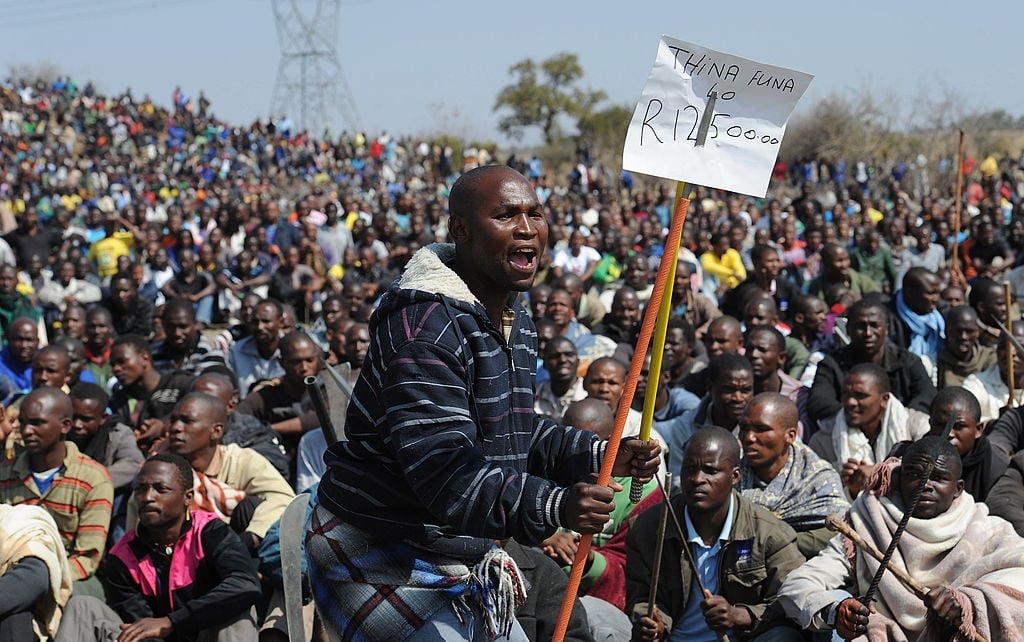 Striking mine workers demonstrate as they protest over wage demands outside the Nkageng informal settlement on 16 August 2012.