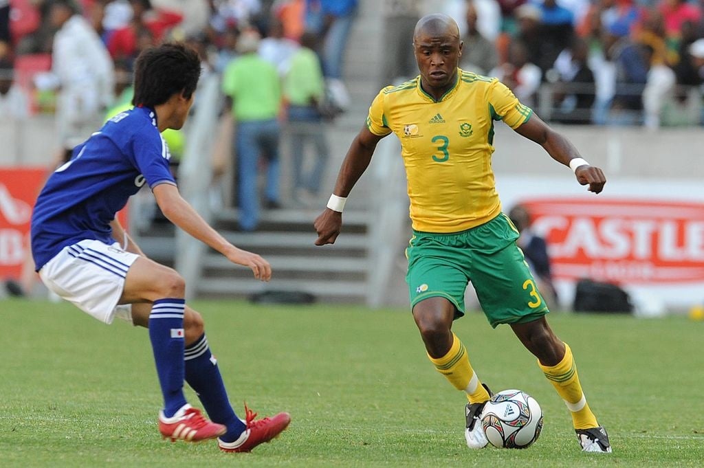 PORT ELIZABETH, SOUTH AFRICA - NOVEMBER 14: Atsuto Uchida challenges Tshepo Masilela during the international match between South Africa and Japan at Nelson Mandela Bay Stadium on November 14, 2009 in Port Elizabeth, South Africa. (Photo by Lefty Shivambu/Gallo Images/Getty Images)