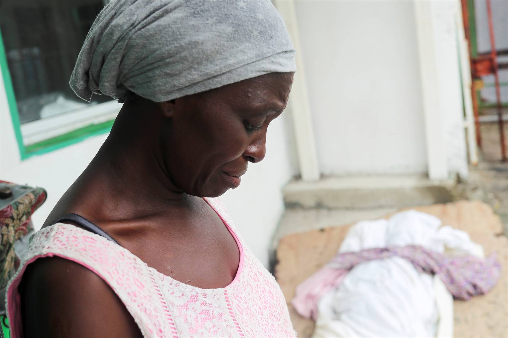 Lanette Nuel langs die lyk van haar dogter, Lonia Bernard (26), buite ’n hospitaal in Les Cayes, Haïti. Foto: Reuters 