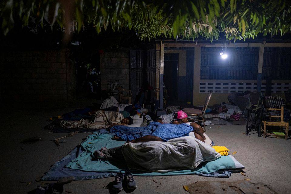 Mense slaap Donderdagnag buite hul huis in die kusstad Les Cayes, een van die gebiede wat die ergste deur Saterdag se aardbewing van 7,2 geraak is. Nuwe naskokke is Donderdagnag hier gevoel.  Foto: Reuters/Ricardo Arduengo