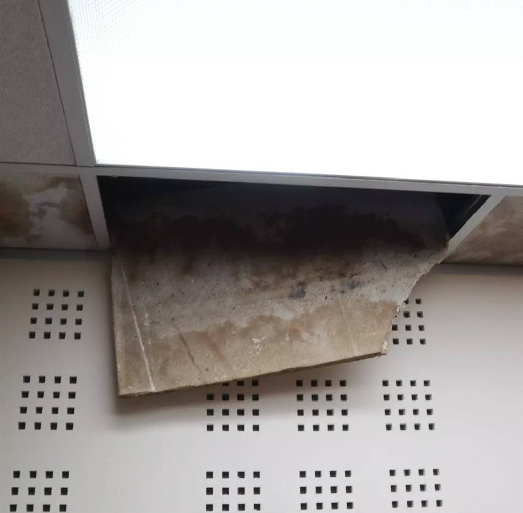Damaged ceiling tiles hanging from roof