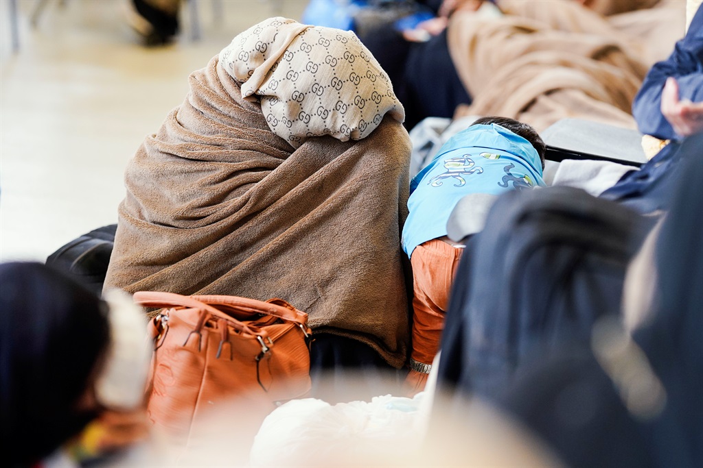 A woman evacuated from Afghanistan sits in a hanga