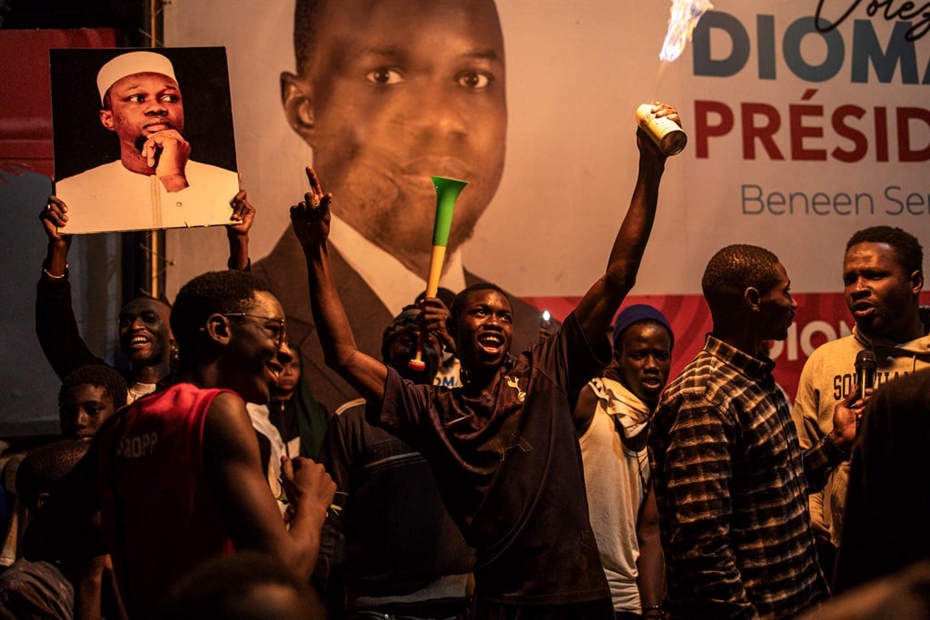 Supporters of Bassirou Diomaye Faye and fellow opposition leader Ousmane Sonko celebrate on 24 March 2024, in Dakar. (JOHN WESSELS / AFP)