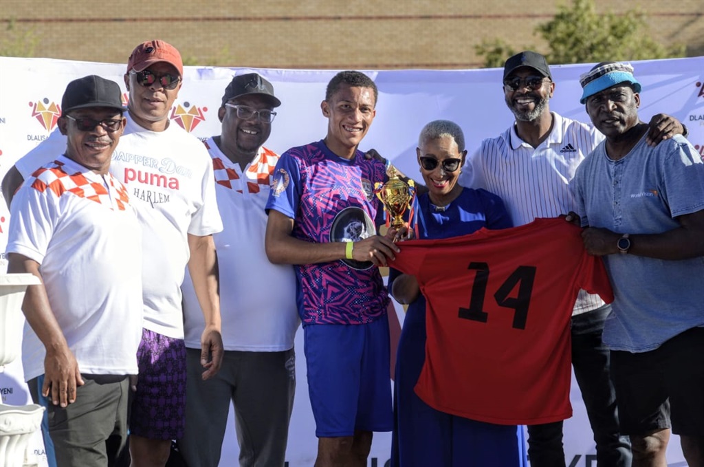 Ria Ledwaba presents a trophy and soccer jersey to