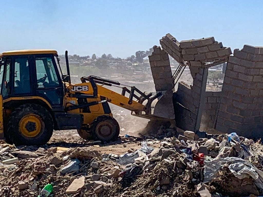 Excavator demolishes one  of the houses built illegally on invaded land in Ebony Park.