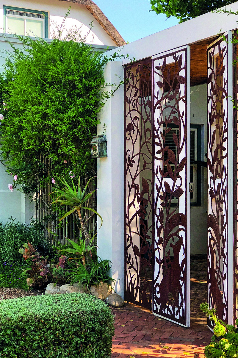 A beautiful steel security gate that pays tribute to the homeowners’ love of dogs has been left to rust for an attractive patina and an old-world look. The steel was cut by hand with an oxyacetylene torch and then fitted onto a wooden frame, which is lockable. Gate design by artist Andrea Desmond-Smith and the late Kobus Stander