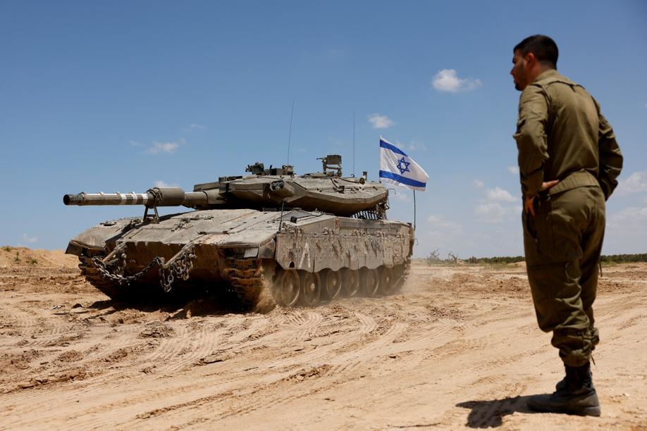 An Israeli soldier stands next to a tank, amid the ongoing conflict between Israel and the Palestinian Islamist group Hamas, near the Israel-Gaza Border, in southern Israel, May 7, 2024. REUTERS/Amir Cohen