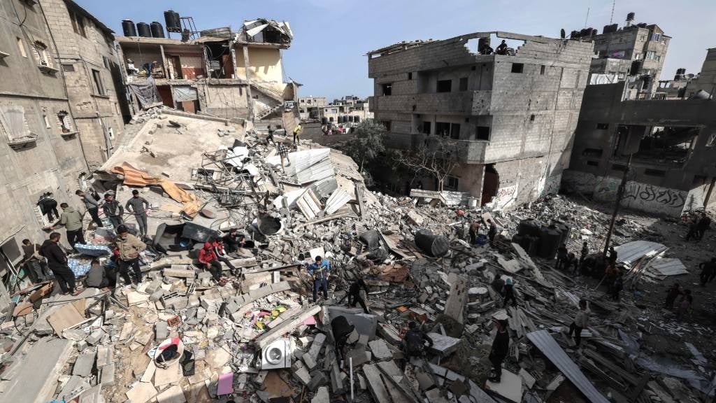 Palestinians check the rubble of buildings that were destroyed following overnight Israeli bombardment in Rafah, in the southern Gaza Strip, on 27 March 2024, amid the ongoing conflict between Israel and the Palestinian militant group Hamas. (Mohammed Abed/AFP)