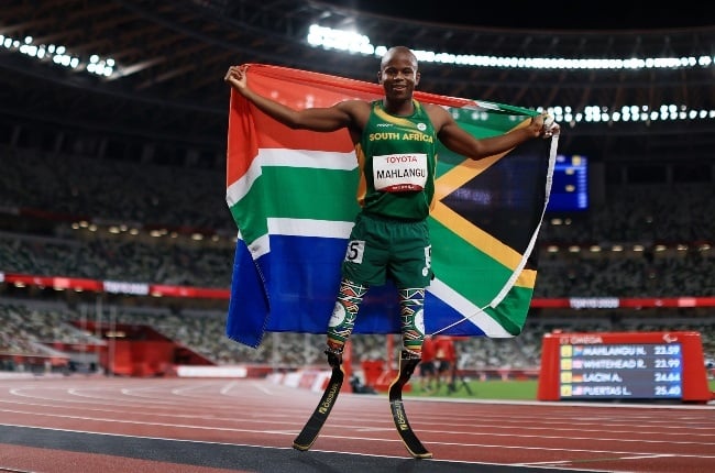 Ntando Mahlangu proudly holds the SA flag after winning gold in the Men's 200m final. (PHOTO: Getty Images/ Gallo Images)