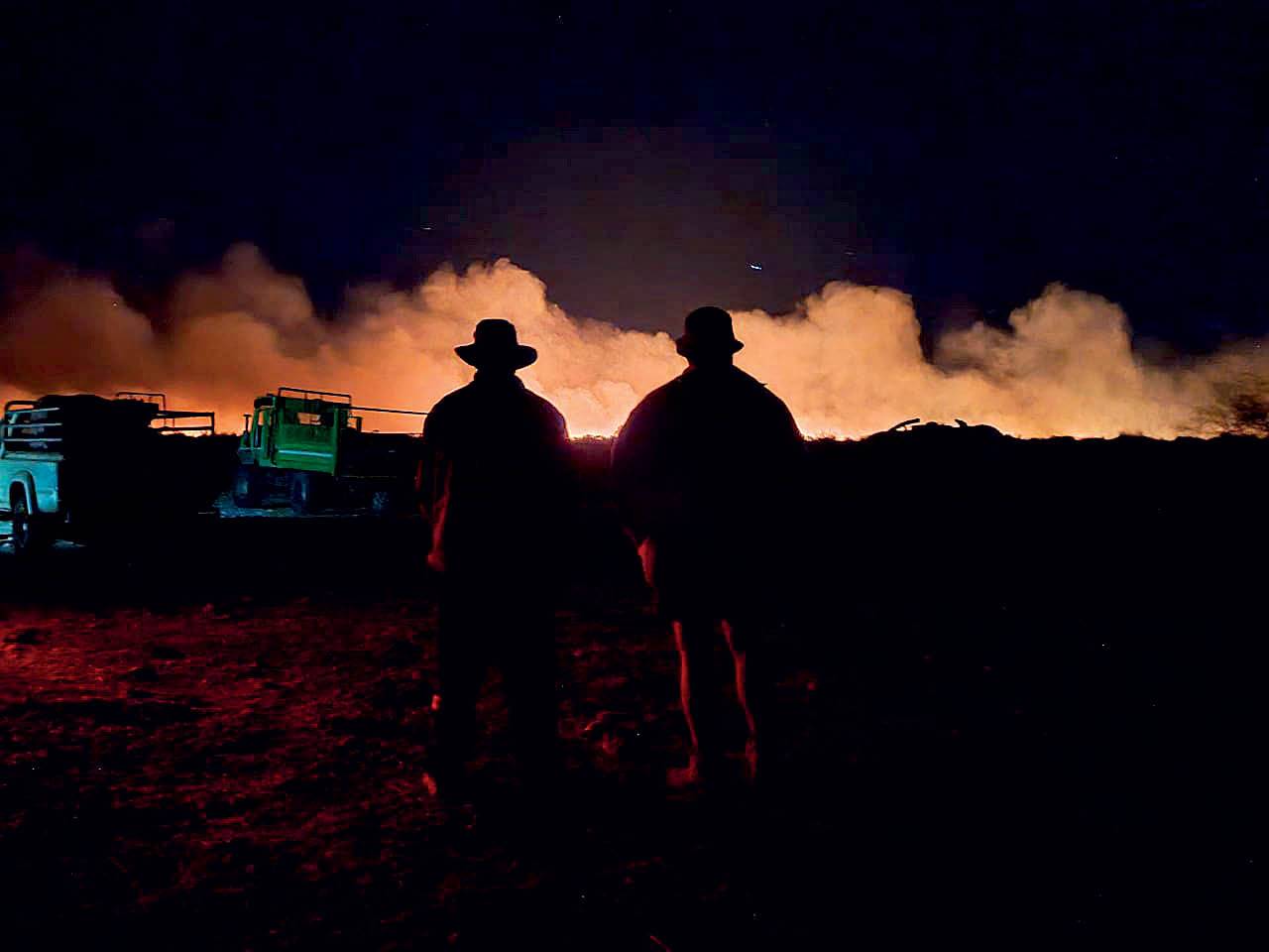 Boere kyk hoe vlamme begin September weiding in die John Taolo Gaetsewe-distrik in die Noord-Kaap tydens ’n vernietigende brand verswelg. Foto: VERSKAF