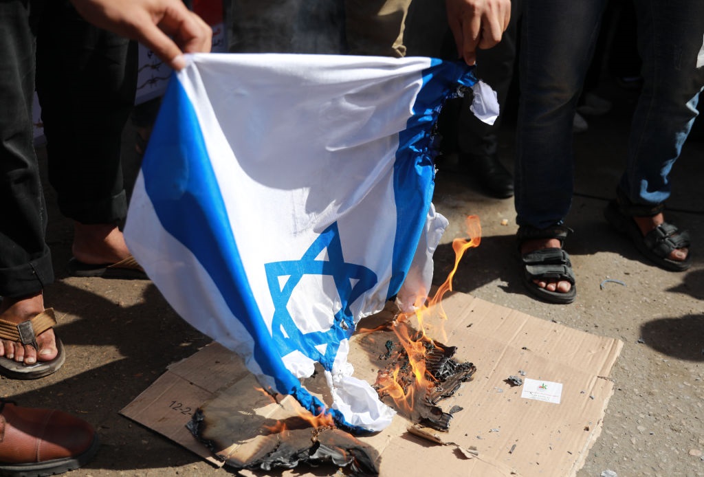 Palestinians burn an Israeli flag during a rally n