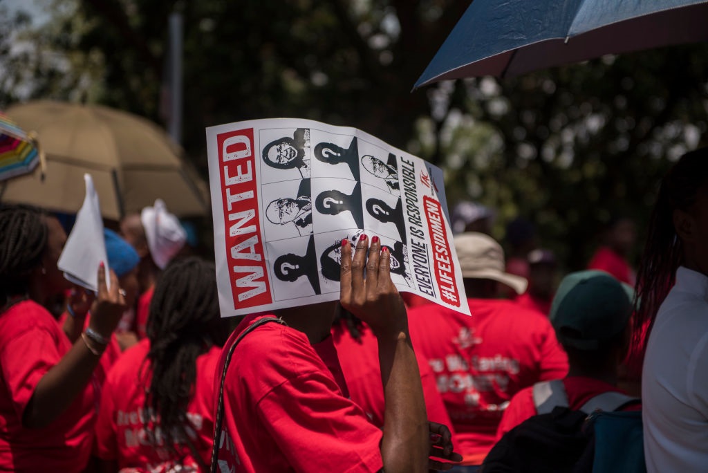 Protesters holding signs condemning Life Esidimeni tragedy
