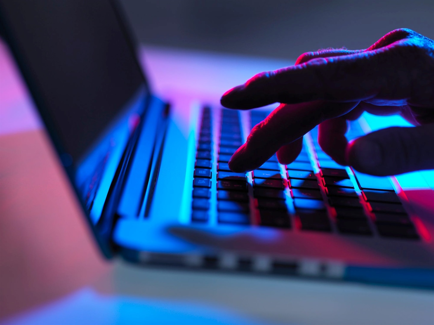 A hand rests on a laptop computer under dark lighting, implying misbehaviour. Andrew Brookes/Getty Images