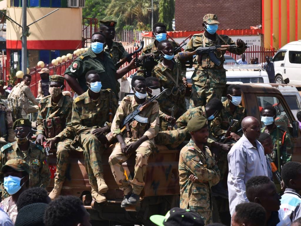 Las fuerzas de seguridad sudanesas vigilan mientras protec