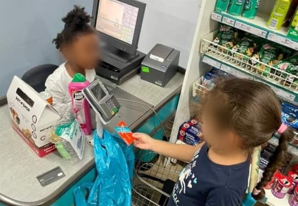 One of the images in question, from now-deleted social media posts by Curro, shows a black child portrayed as a cashier serving a white child. (Image via X)
