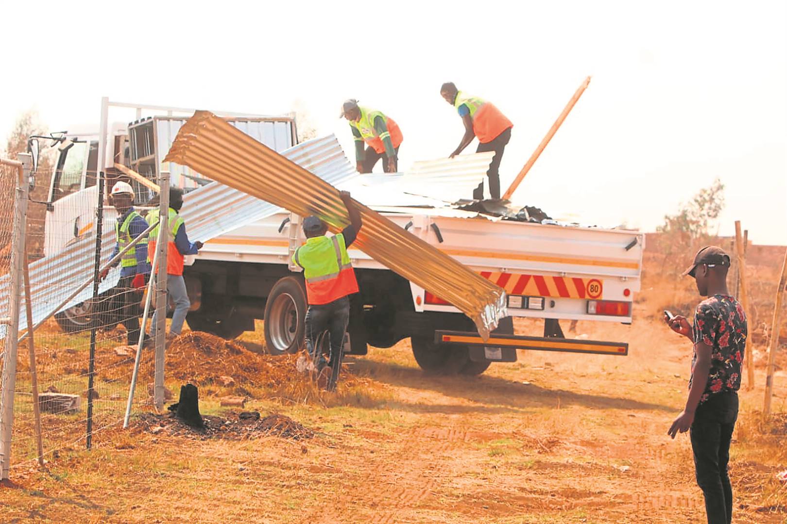 Members of the Land Invasion Unit demolishing shacks built illegally on land meant for RDP houses in Lehae.         Photo by Raymond Morare