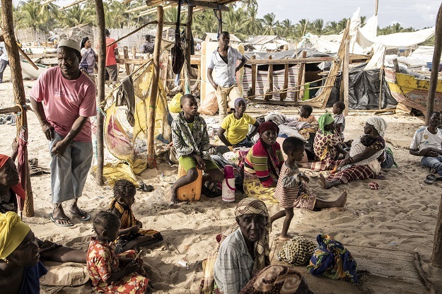 People gather under a makeshift displacement shelter in Pemba after fleeing insurgency-hit Palma by boat.