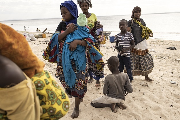 People carry their belongings off a boat as they a