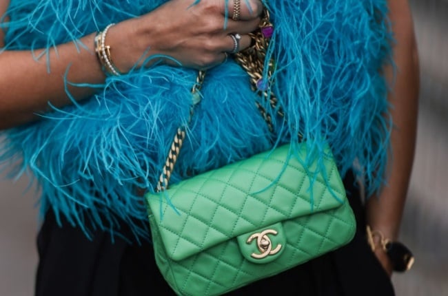 Karin Teigl wearing a blue top, black pants and a green chanel bag outside L Oreal Show on October 03, 2021 in Paris, France. Photo by Jeremy Moeller/Getty Images