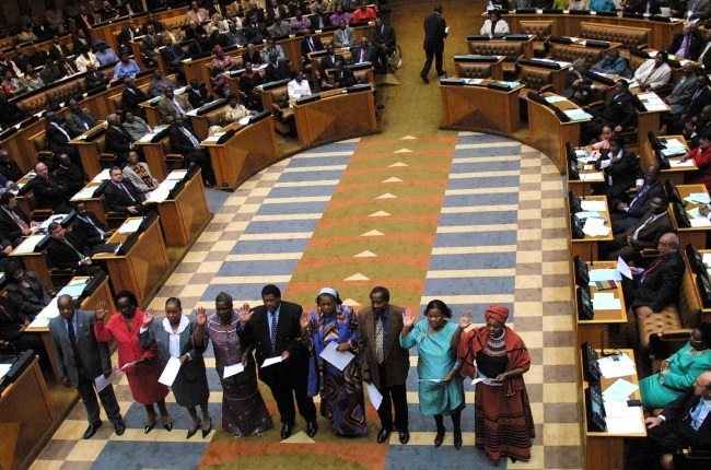 Members of parliament are sworn in by Chief Justice Arthur Chaskalson (unseen) in the National Assembly, in Cape Town 23 April 2004. Mbeki's African National Congress (ANC) party won a landslide victory in the April 14 elections, picking up just under 70 percent of the vote and a whopping 279 seats in the 400-member National Assembly, its largest majority in a decade in power. 