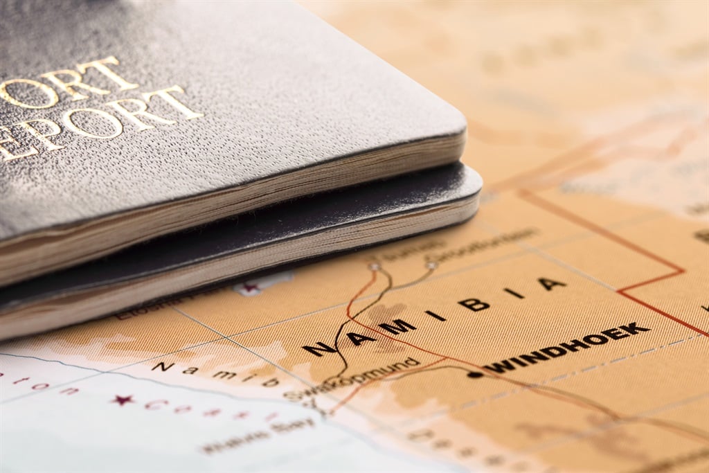 Two passports on the map of Namibia, are ready for travel. 