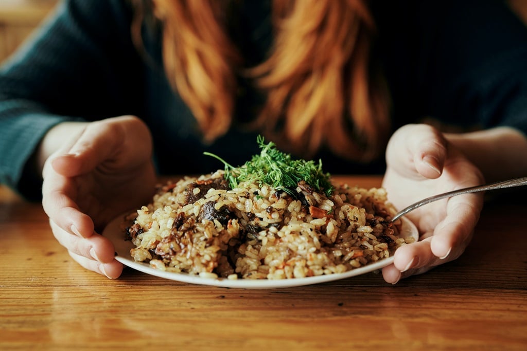 Woman holding a plate of rice. (Getty Images)