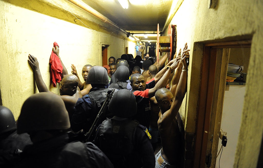 Hostel dwellers line up during a raid in Johannesburg in 2015.