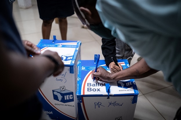 IEC staff inspect ballot papers in boxes. 