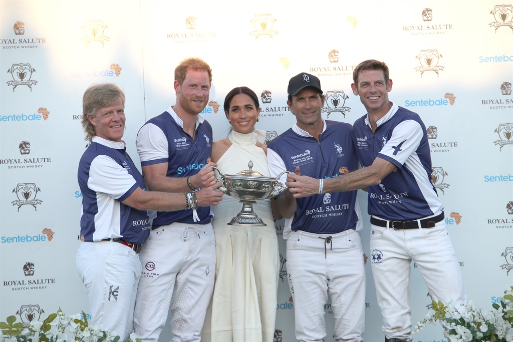 The Duchess of Sussex presents the trophy to her h