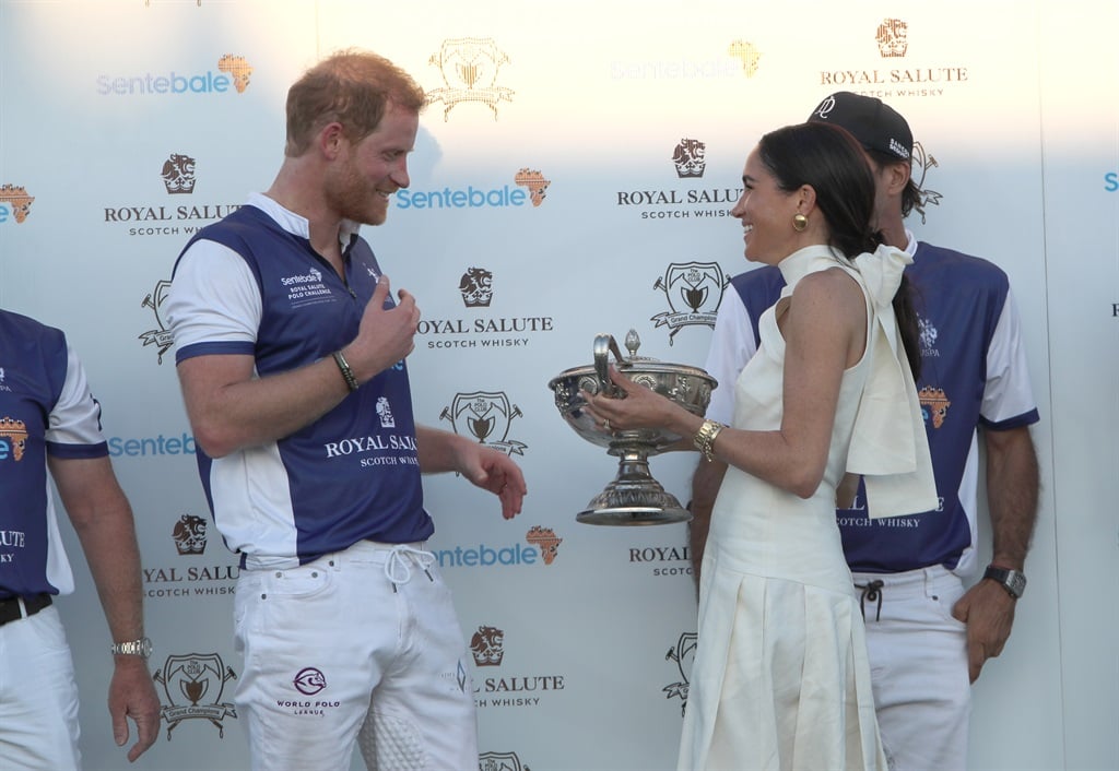 The Duchess of Sussex presents the trophy to her h