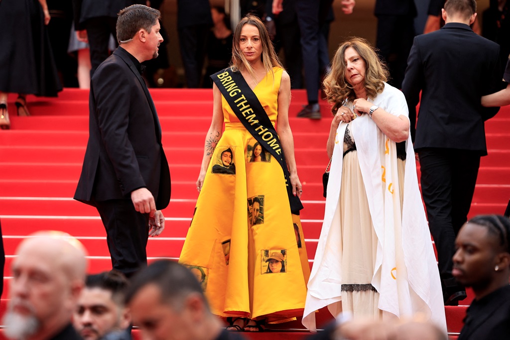 Laura Blajman-Kadar, a survivor of the 7 October attacks by Palestinian Hamas militants wears a scarf reading "Bring them home" as she arrives for the screening of the film "Furiosa: A Mad Max Saga" at the 77th edition of the Cannes Film Festival in Cannes, southern France, on 15 May 2024. (Valery HACHE / AFP)